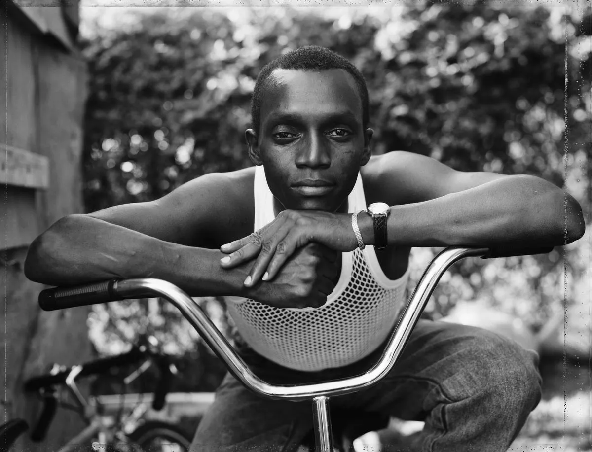 Dawoud Bey, A Young Man Resting on an Exercise Bike, Amityville, NY, from the series Street Portraits, 1988