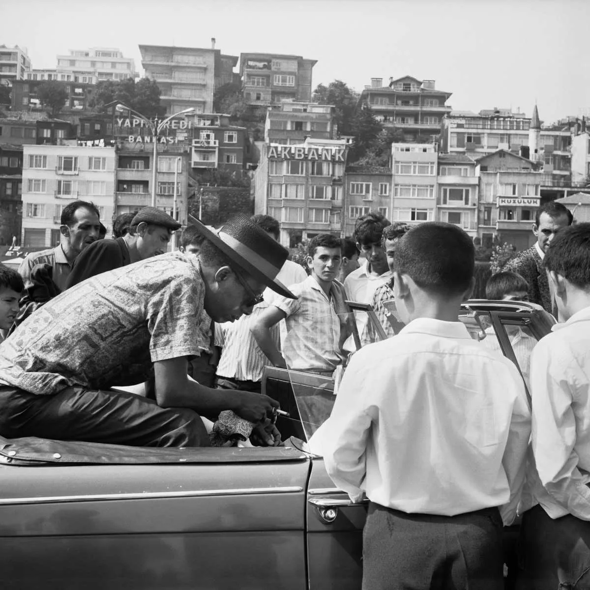 Baldwin sitting in a Triumph Herald on the Bosporus Ferry