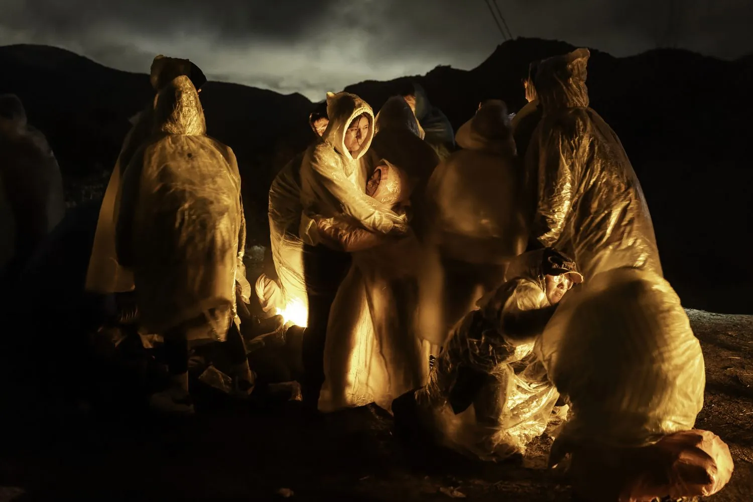 Chinese migrants warm themselves during a cold rain after crossing the US–Mexico border. Campo, California, 7 March 2024.