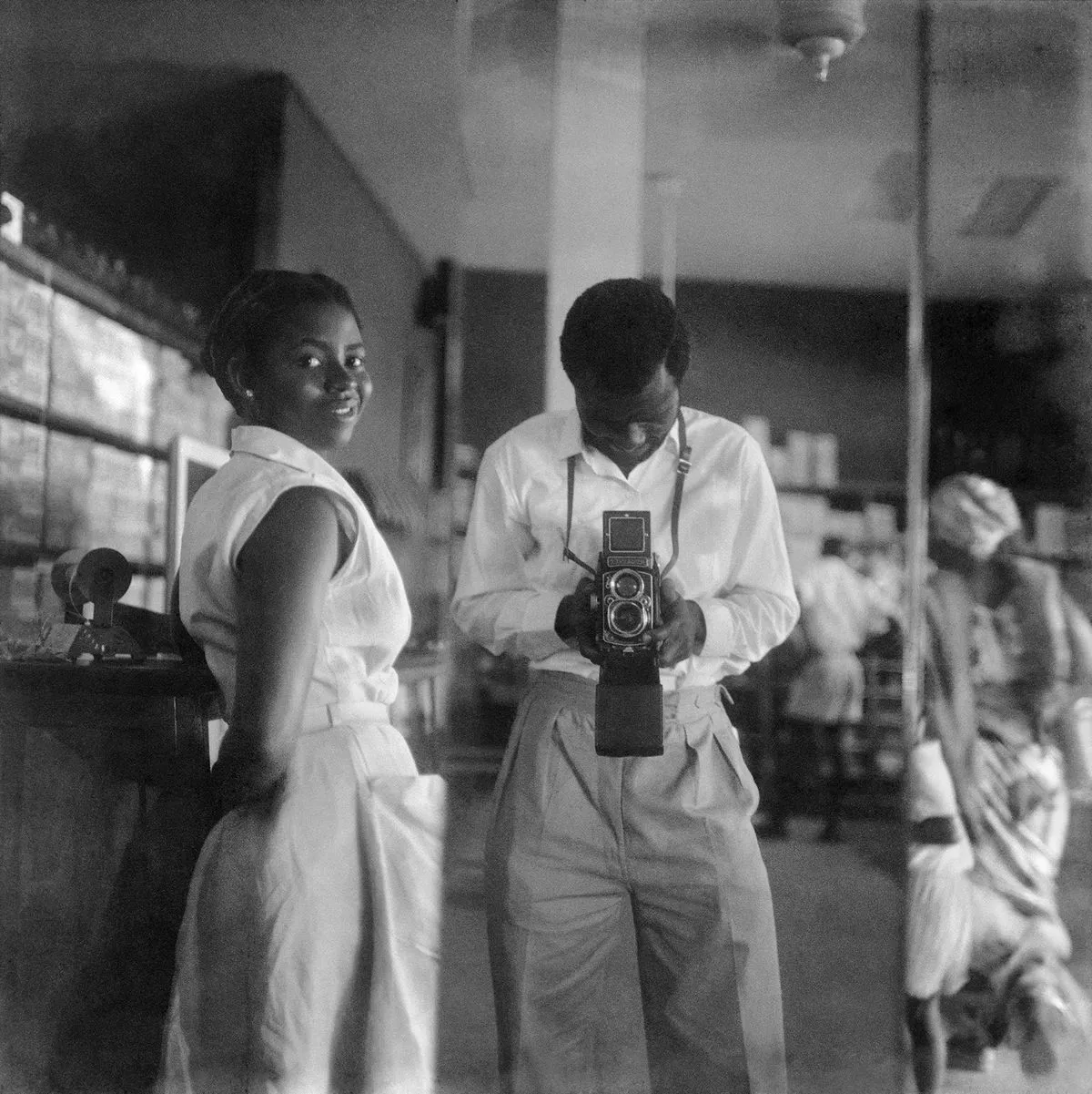 James Barnor, Self-portrait with a store assistant at the West African Drug Company, central Accra, 1952