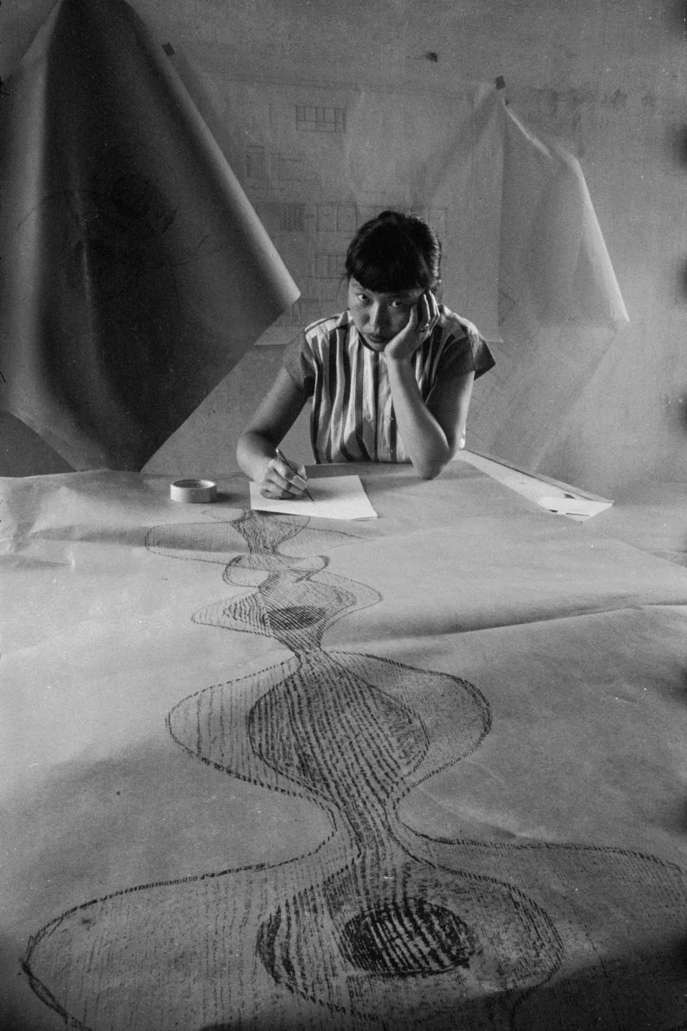 Portrait of Japanese American artist sculptor Ruth Asawa as she sketches a design, 1954