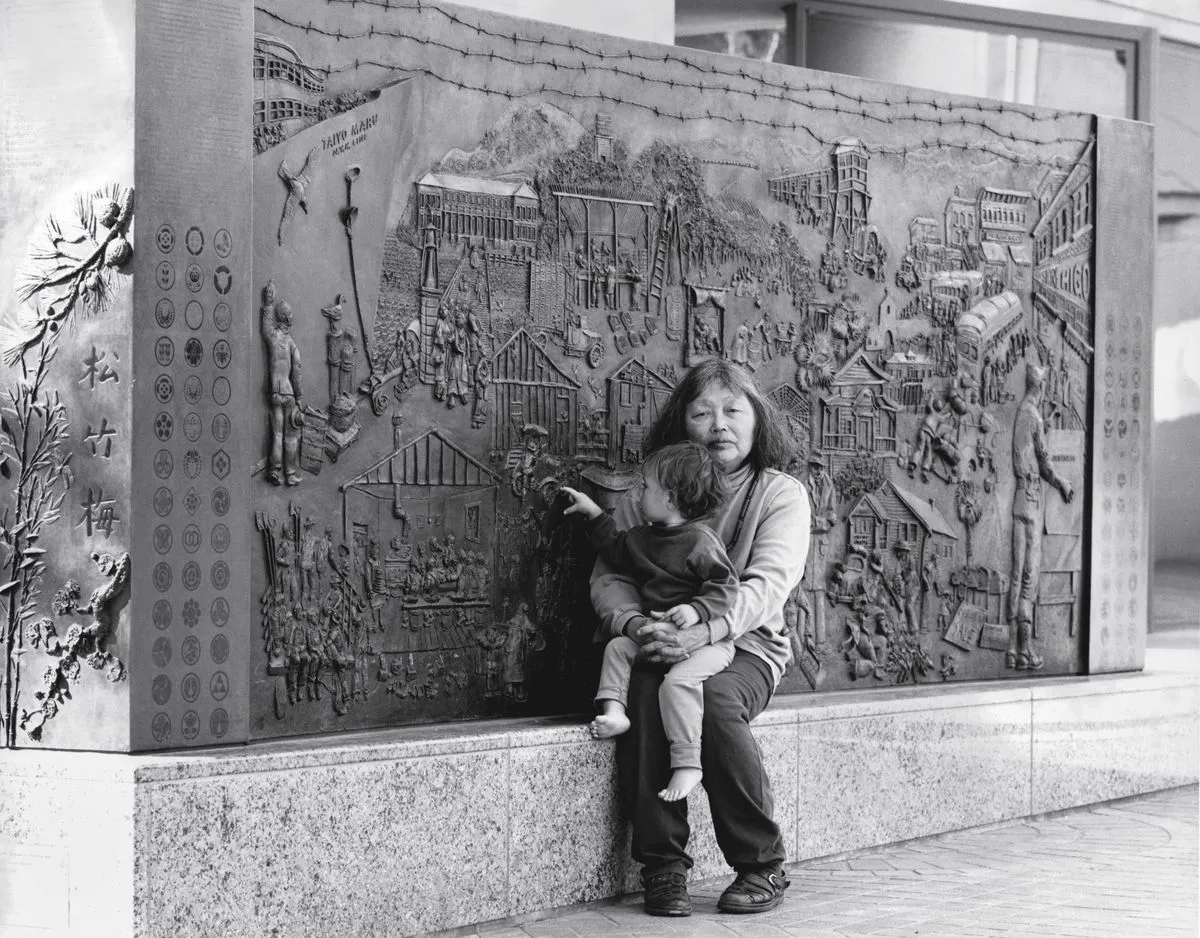 Ruth Asawa and her granddaughter with Japanese American Internment Memorial (PC.011), 1990 -94, commissioned by the City of San José