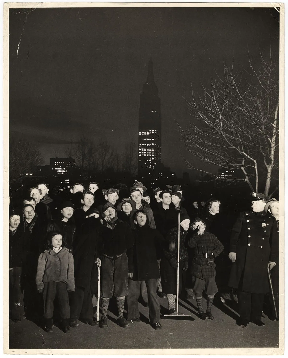 Weegee, Night.. a black velvet curtain has dropped over the white sky.. a few mothers went
looking for their kids... found them here... dragged them home for supper... but they are back
again... but that's the same Empire State Building in the Back